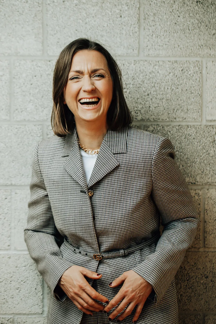 Svenja lacht herzlich, im karierten Blazer